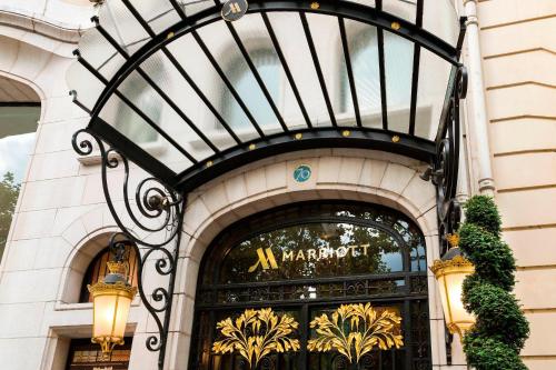 une porte d'entrée d'un bâtiment avec un panneau sur celui-ci dans l'établissement Paris Marriott Champs Elysees Hotel, à Paris