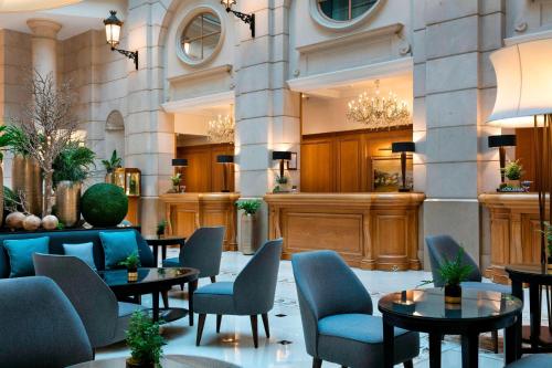eine Lobby mit Tischen und Stühlen in einem Gebäude in der Unterkunft Paris Marriott Champs Elysees Hotel in Paris