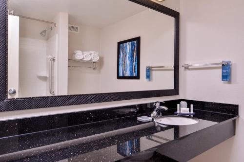 baño con lavabo y espejo grande en Fairfield Inn & Suites Raleigh-Durham Airport/Brier Creek, en Durham