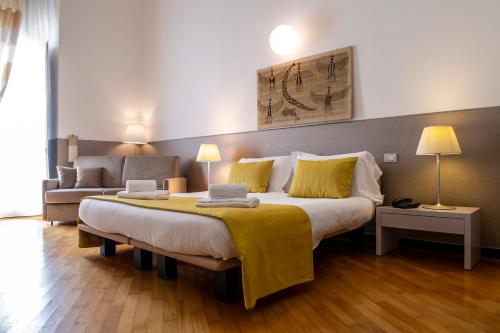 a bedroom with a large bed and a couch at Palazzo Indelli in Monopoli