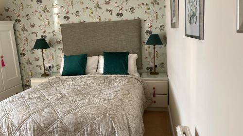 a bedroom with a bed with green pillows at Thistle House Guest House in Saint Catherines