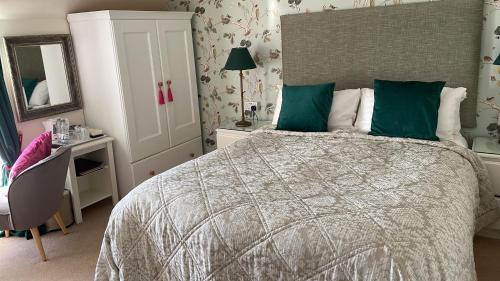 a bedroom with a bed and a desk and a mirror at Thistle House Guest House in Saint Catherines