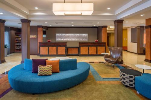 vestíbulo con sofá azul y silla en Fairfield Inn & Suites by Marriott Portland North, en Portland