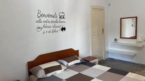 a bedroom with a bed and words on the wall at La dimora nonna Eugy in Polignano a Mare