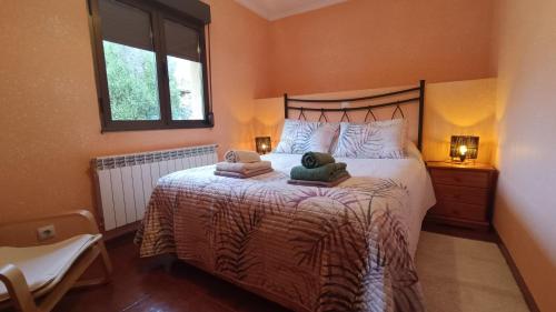 a bedroom with a bed with two towels on it at Casa Millar. in Huergas y El Millar