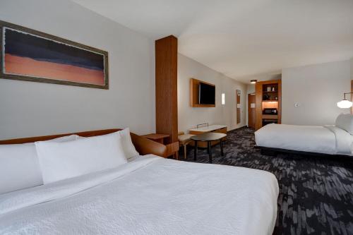 ein Hotelzimmer mit 2 Betten und einem Schreibtisch in der Unterkunft Fairfield by Marriott Inn & Suites Grand Rapids Wyoming in Wyoming