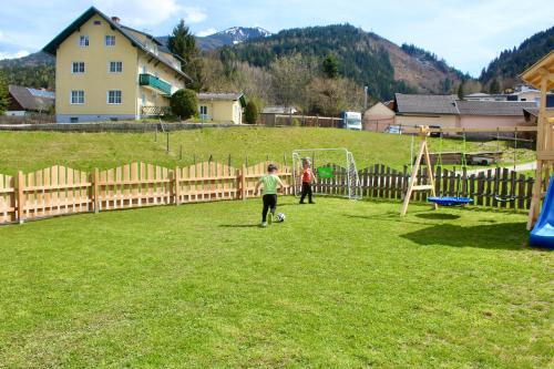 two children playing with a soccer ball in a field at Chalet Mama in Pruggern