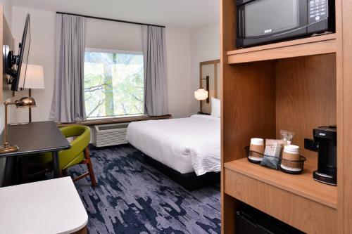 Fairfield Inn and Suites by Marriott Minneapolis Shakopee في شاكوبي: غرفه فندقيه سرير وتلفزيون