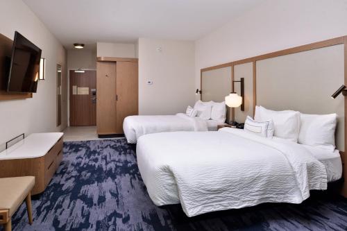 a hotel room with two beds and a flat screen tv at Fairfield Inn and Suites by Marriott Minneapolis Shakopee in Shakopee