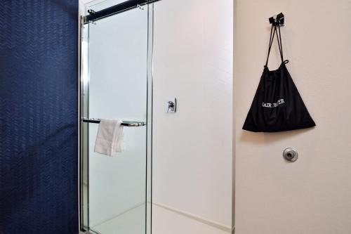 una cabina de ducha de cristal con una bolsa negra en la pared en Fairfield Inn and Suites by Marriott Minneapolis Shakopee en Shakopee