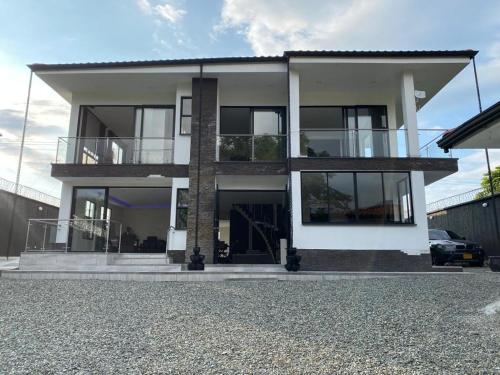 a large white house with a lot of windows at Chalet El Pilar Bacelona Quindio in Barcelona