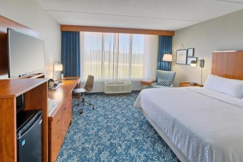 a hotel room with a bed and a flat screen tv at Four Points by Sheraton Raleigh Durham Airport in Morrisville