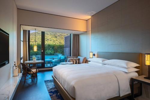 sypialnia z dużym łóżkiem i dużym oknem w obiekcie Renaissance Taipei Shihlin Hotel w Tajpej