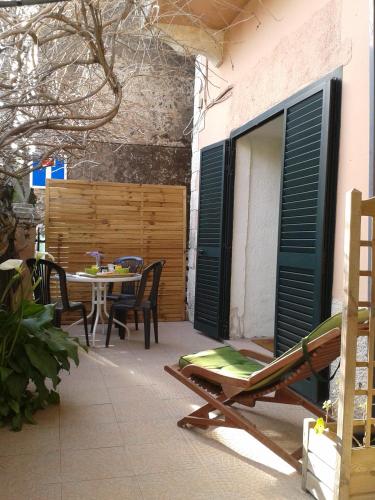 un patio con mesa, sillas y una mesa con puerta en Le Clos Osteria, en Barbaggio