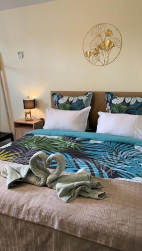 2 cygnes assis au-dessus d'un lit dans l'établissement Studio de Célestine, à Vernon