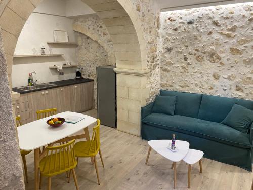 a living room with a couch and a table and chairs at Barbara Studios in Rethymno