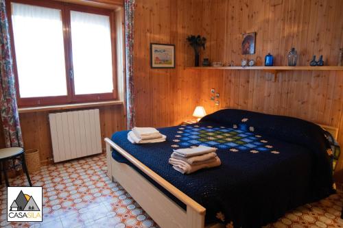 Un pat sau paturi într-o cameră la "CASA SILA", Delizioso appartamento in pieno centro a Camigliatello, 4 posti letto, 2 camere, arredato in vero stile casa di montagna
