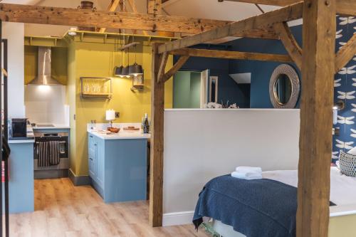 een kamer met een bed en een keuken met gele muren bij The Woodshop in Darlington