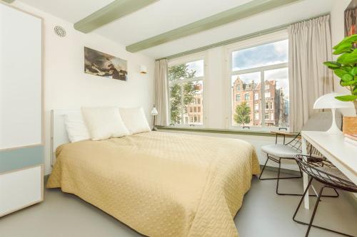 - une chambre avec un lit, un bureau et une fenêtre dans l'établissement The Red Ox - Super Central Canal View Rooms, à Amsterdam