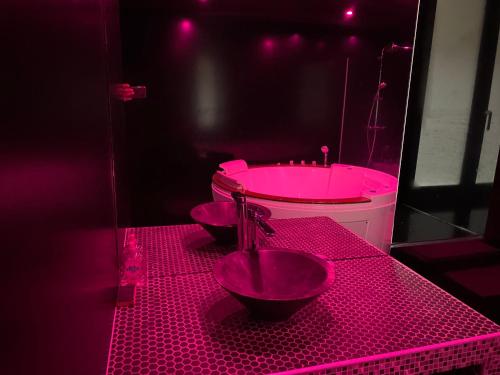 a pink bathroom with a toilet and a sink at La Suite Marylin, Loft de 90m2 avec Sauna et Jacuzzi in Riom