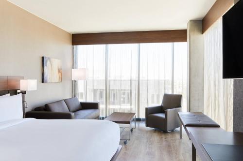 ソルトレイクシティにあるAC Hotel By Marriott Salt Lake City Downtownのベッドと大きな窓が備わるホテルルームです。