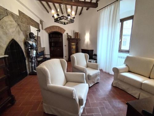 a living room with white chairs and a statue at APPARTAMENTO CISTERNA 33 in San Gimignano
