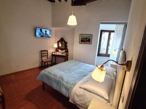 a bedroom with a bed and a desk with a lamp at APPARTAMENTO CISTERNA 33 in San Gimignano