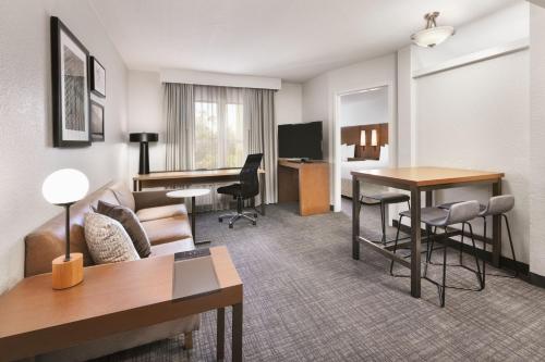 a hotel room with a couch and a desk at Residence Inn by Marriott Daytona Beach Speedway/Airport in Daytona Beach