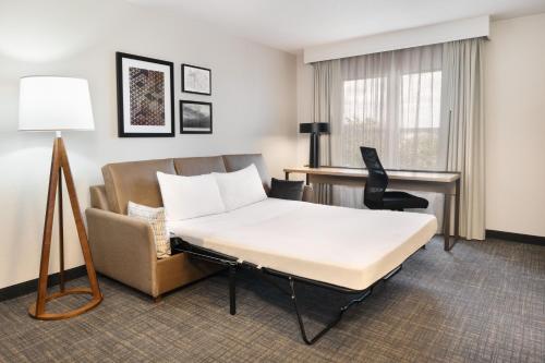 a hotel room with a bed and a desk at Residence Inn by Marriott Daytona Beach Speedway/Airport in Daytona Beach