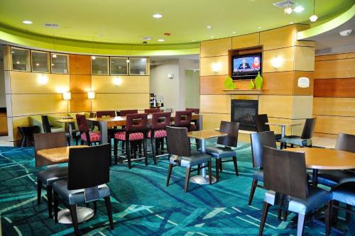 a restaurant with tables and chairs and a television at SpringHill Suites Galveston Island in Galveston