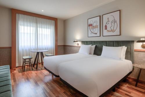 マドリードにあるAC ホテル アラバカのホテルルーム内の大きな白いベッド