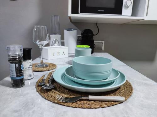 une table avec une assiette de vaisselle et un four micro-ondes dans l'établissement Chonguile Villa 1 Modern Minimalist in Matola, à Matola