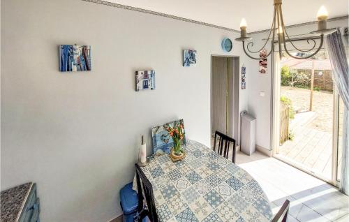 une salle à manger avec une table et un vase de fleurs. dans l'établissement Amazing Home In Saint-Georges-De-Didon, à Saint-Georges-de-Didonne