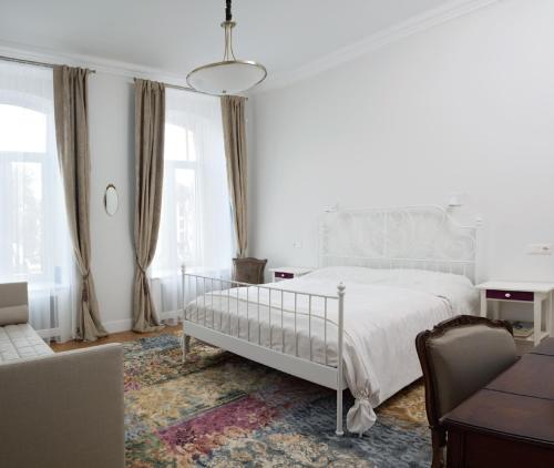 um quarto branco com uma cama e uma cadeira em Cosy Old Vilnius em Vilnius