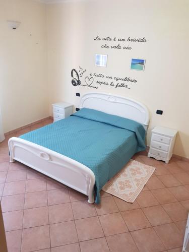 ein Schlafzimmer mit einem Bett mit einem Zitat an der Wand in der Unterkunft Casa vacanza Tommy in Pabillonis