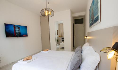 a bedroom with a white bed and a tv on the wall at Marco Polo in Petrovac na Moru