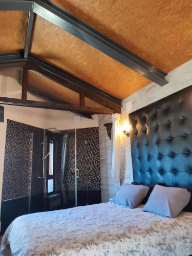a bedroom with a large bed with a blue headboard at la casa de las cabilas in Cuevas del Valle