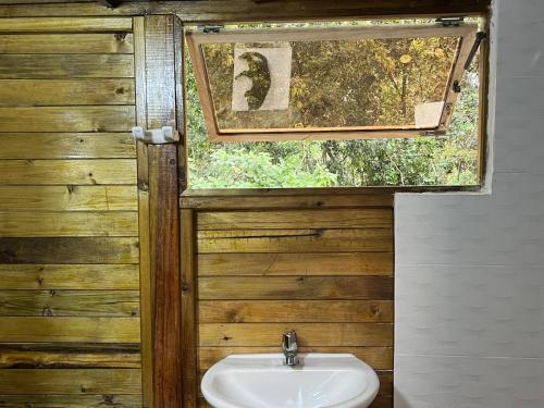 baño con lavabo y ventana en Villa Feliz Ecolodge, en Monterrey