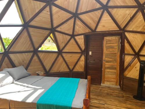 1 dormitorio con 1 cama en una habitación de madera en Villa Feliz Ecolodge, en Monterrey