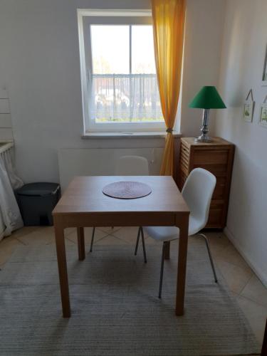 a table and two chairs in a room with a window at 1-Zimmer-Apartment "Meeresrauschen" in Peenemünde in Peenemünde