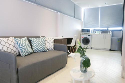 a living room with a couch and a table at Comfy Studio 2 by Recharge in Singapore