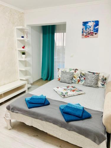a bedroom with a bed with blue pillows on it at Apartament litoral in Saturn