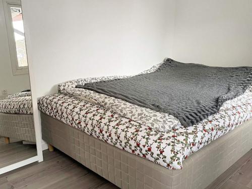 een bed met een dekbed in een kamer bij Holiday home HAKENÄSET IV in Balkeröd