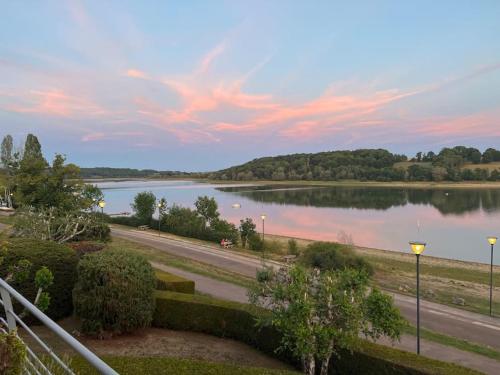 a view of a river with a road and a lake at Maison cadre paisible face au lac in Peigney