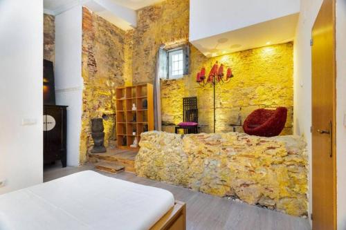 een kamer met een stenen muur en een bank. bij Kuta Loft Alfama in Lissabon
