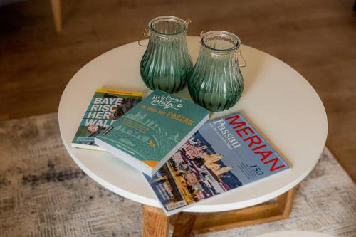 a table with two green vases and magazines on it at Servus Apartment Neuhaus am Inn2 in Neuhaus am Inn