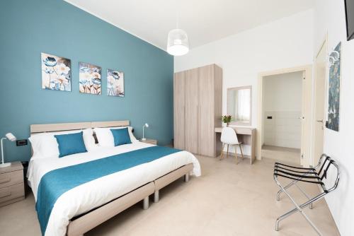 - une chambre avec un grand lit et un mur bleu dans l'établissement B&b Casa Spano, à Selargius
