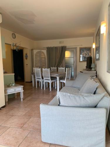 sala de estar con sofá, mesa y sillas en Residence Il Fiocco en San Vincenzo