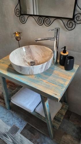 a bathroom sink on a wooden table with a counter at Blue house II in Palekastron