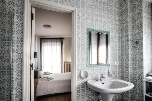 a bathroom with a sink and a bed at 2 Santi - Suite and Rooms in Lecce